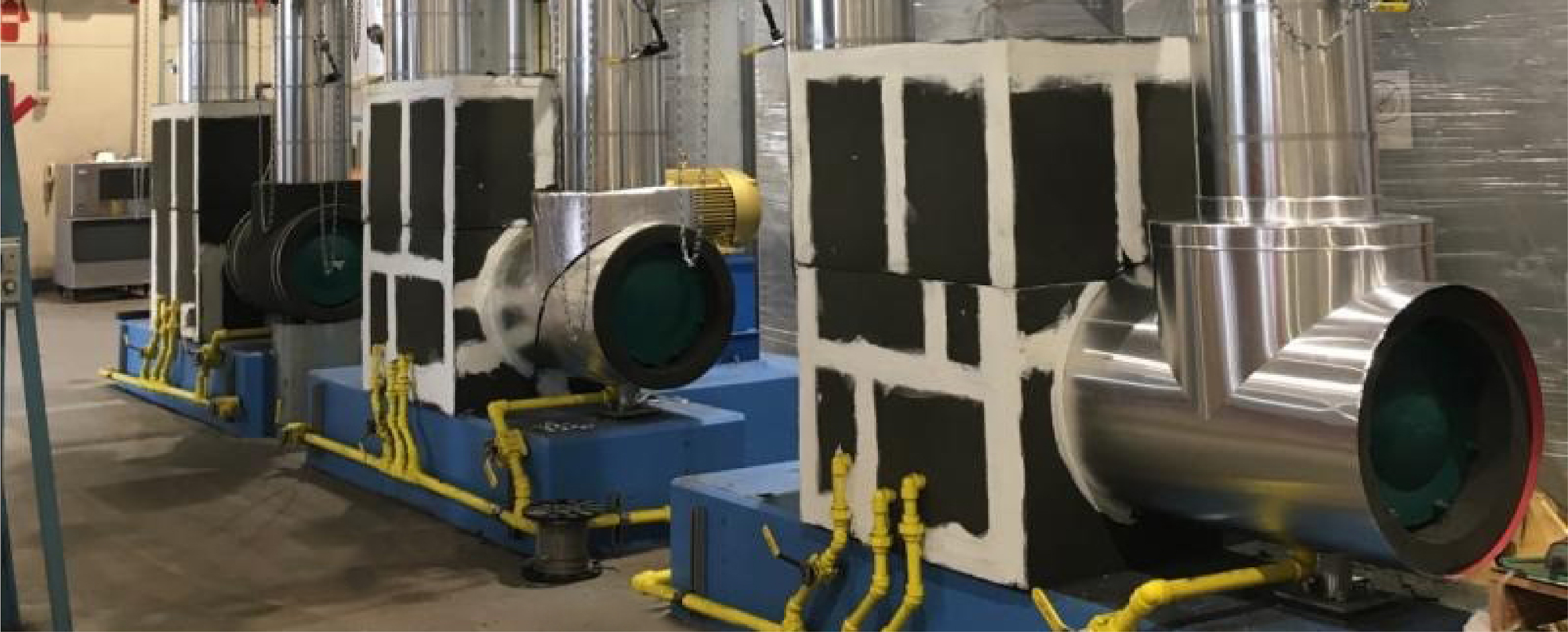 Three large indistrial machones with custom insulation installed on them