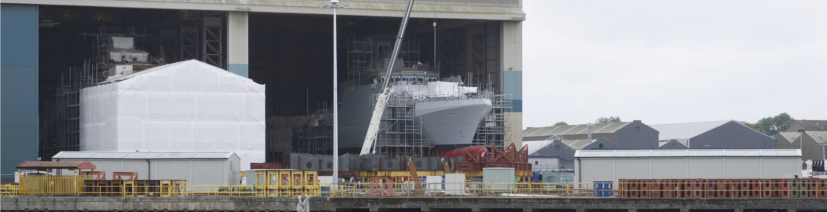 Waterfront pier with ship in covered drydock