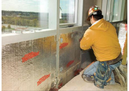 Photo of construction worker installing curtain wall insulation